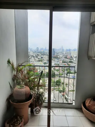 Stunning cityscape view from a high-rise balcony with potted plants.