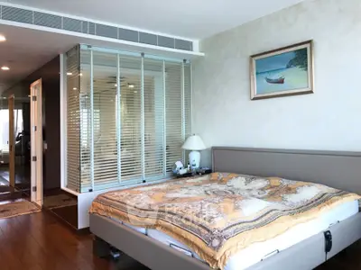 Spacious bedroom with modern decor and large windows for natural light