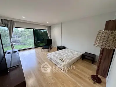 Spacious bedroom with large window and minimalist decor