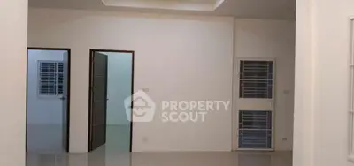 Spacious modern interior with sleek white walls and polished floors, featuring multiple doorways.
