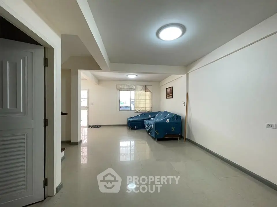 Spacious living room with modern lighting and tiled flooring in a contemporary home.