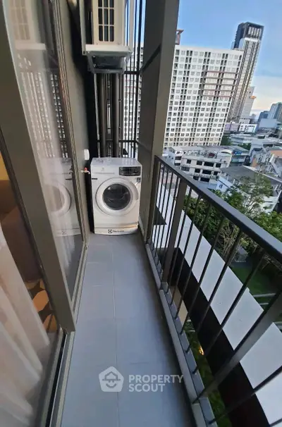 Modern high-rise balcony with washing machine and city view, perfect for urban living.
