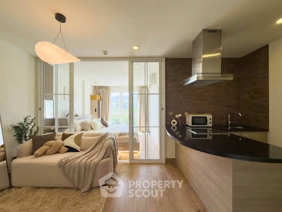Modern open-plan living room with cozy sofa and sleek kitchen design