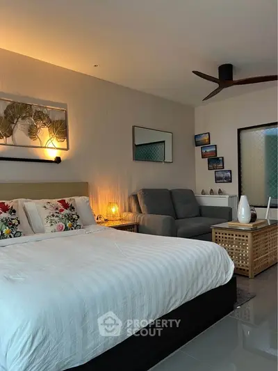Modern bedroom with cozy seating area and stylish decor