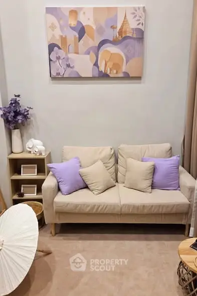 Charming living room with cozy beige sofa, purple accents, and elegant wall art, perfect for relaxation.