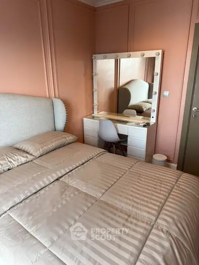 Cozy bedroom with elegant vanity and plush bedding in a stylish apartment.
