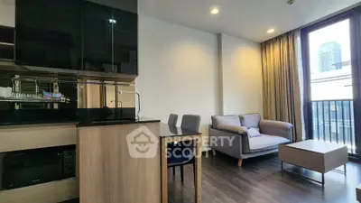 Modern living room with sleek kitchen, cozy seating, and city view balcony in urban apartment.