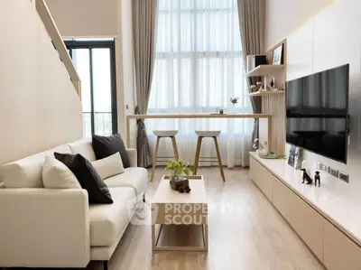 Modern living room with high ceilings, stylish decor, and natural light