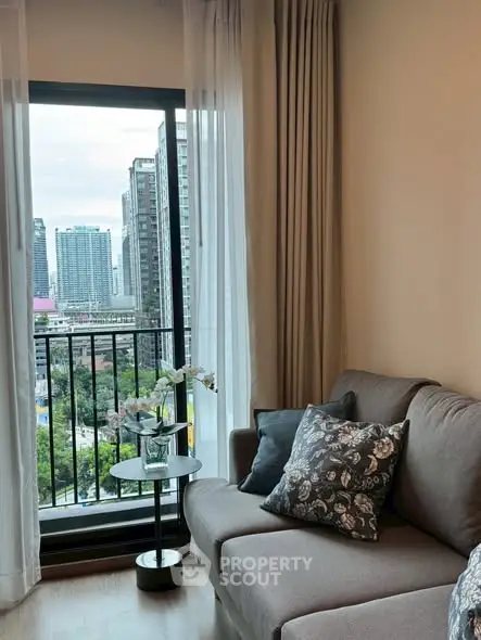 Modern living room with city view from balcony, cozy sofa and elegant decor.