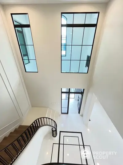 Luxurious multi-level home interior with high ceilings, elegant staircase, and modern skylights offering abundant natural light.