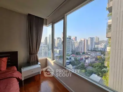 Stunning bedroom with panoramic city view from large windows, featuring elegant decor and natural light.