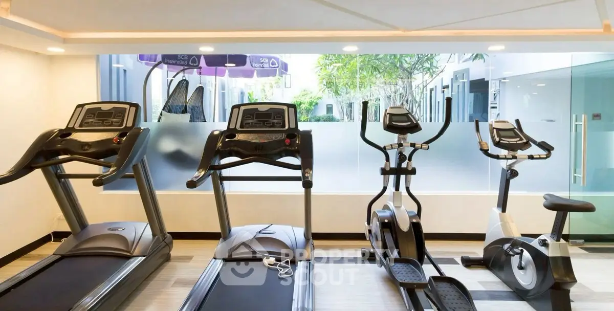 Modern gym with state-of-the-art exercise equipment and bright natural lighting.