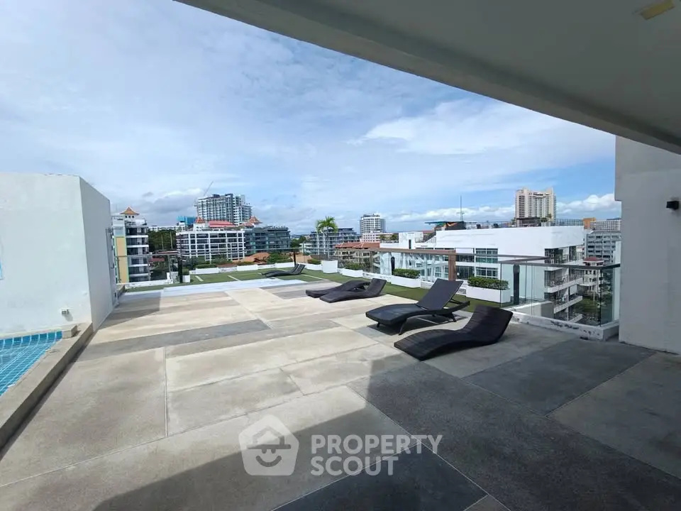 Stunning rooftop terrace with panoramic city views and modern lounge chairs