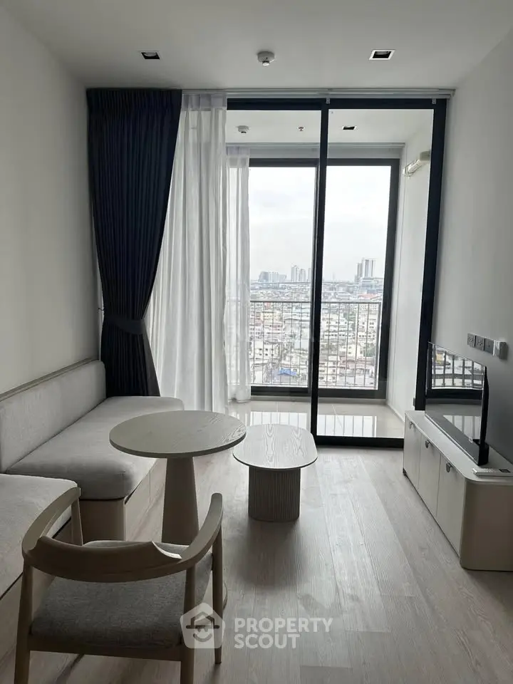 Modern living room with large windows offering stunning city views, minimalist furniture, and elegant decor.