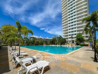 Luxurious high-rise building with a stunning outdoor pool and sun loungers, perfect for relaxation.