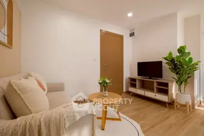 Cozy living room with modern decor, wooden flooring, and a stylish TV unit.