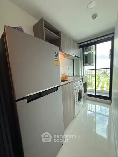 Modern kitchen with sleek appliances and balcony view in a stylish apartment.