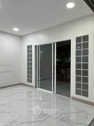 Modern interior with sliding glass doors and marble flooring, perfect for stylish living.