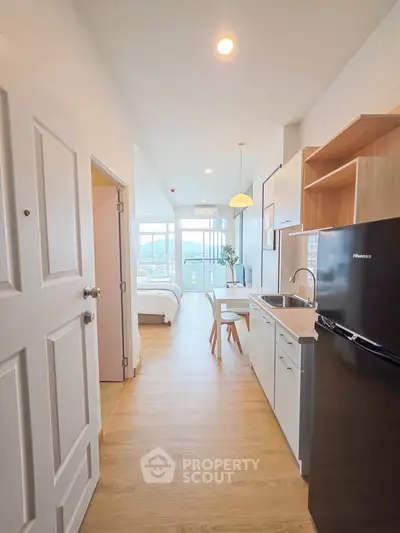Modern apartment interior with open kitchen and cozy bedroom view