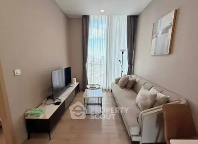 Modern living room with stylish sofa and TV, featuring floor-to-ceiling windows and elegant decor.