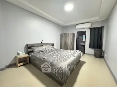 Spacious bedroom with modern decor and ensuite bathroom in a stylish apartment.