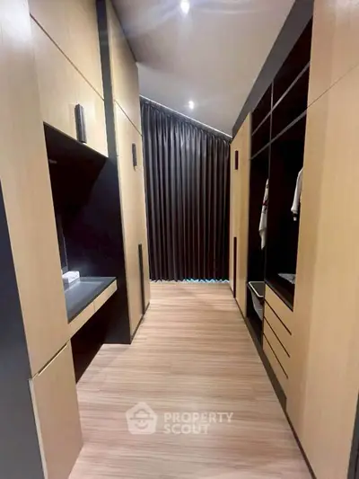 Spacious walk-in closet with modern wooden cabinetry and ample storage space.