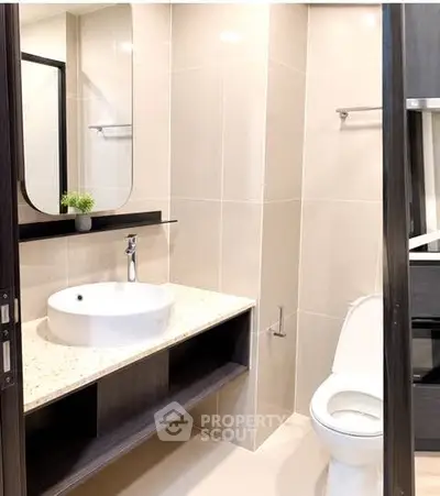 Modern bathroom with sleek fixtures and elegant design, featuring a stylish sink and toilet.