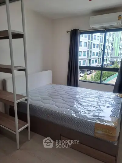Modern bedroom with large window and new mattress in a stylish apartment.