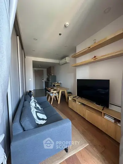Modern living room with sleek furniture and open layout, featuring a cozy sofa and stylish shelving.