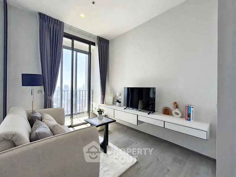 Modern living room with sleek furniture and city view balcony.