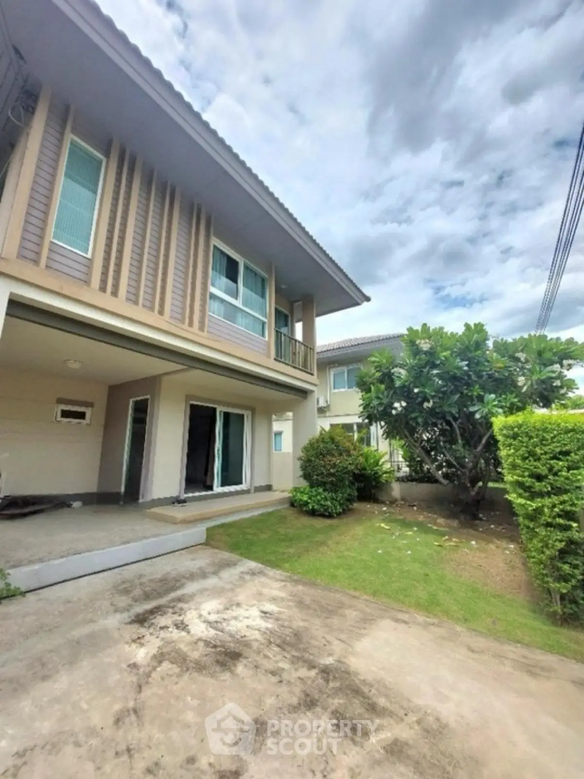 Modern two-story house with lush garden and spacious driveway
