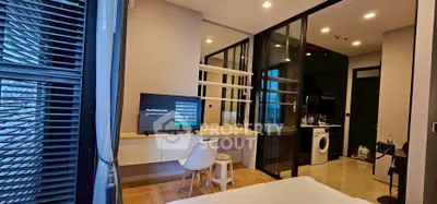 Modern bedroom with TV and washing machine in sleek apartment