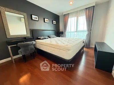 Spacious bedroom with elegant decor and large window for natural light