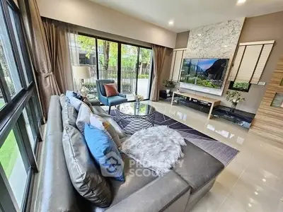 Luxurious modern living room with plush sofa and large windows offering garden view.
