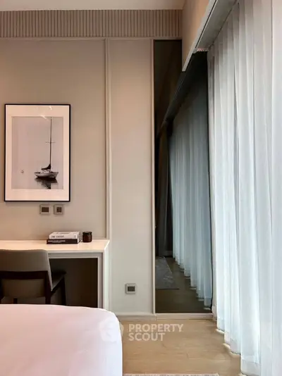 Modern bedroom with elegant decor and floor-to-ceiling windows for natural light.