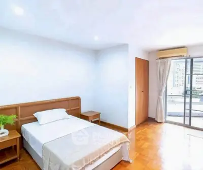 Spacious bedroom with balcony access in modern apartment