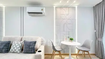 Modern living room with stylish decor, featuring a cozy sofa, chic dining set, and elegant wall design.