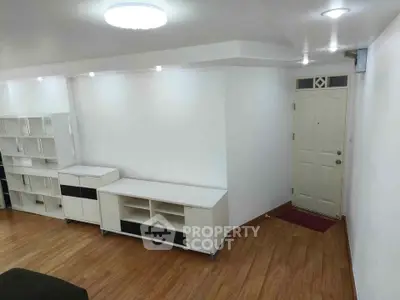 Spacious living room with modern white furniture and wooden flooring