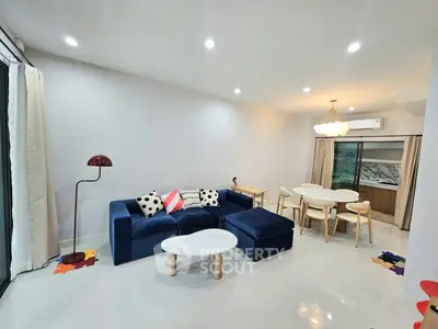 Modern living room with stylish blue sofa and elegant dining area