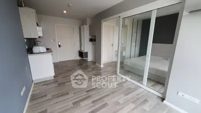 Modern studio apartment with sleek flooring and mirrored closet doors