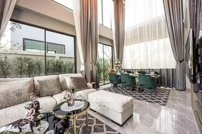 Luxurious modern living room with high ceilings and elegant dining area, featuring floor-to-ceiling windows.