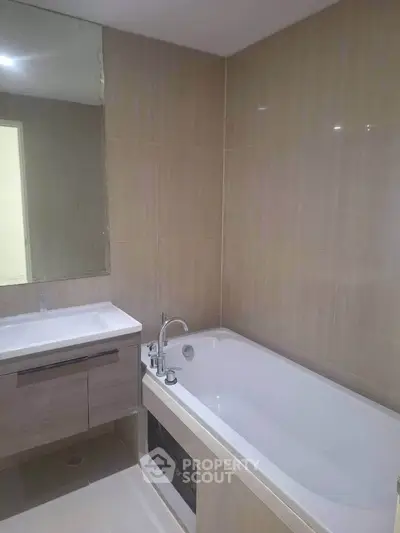 Modern bathroom with sleek bathtub and stylish vanity in a contemporary home.