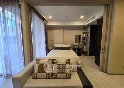 Luxurious bedroom with modern decor and large windows for natural light.