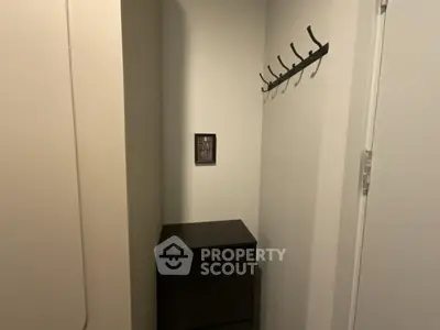 Compact storage area with wall hooks and cabinet in modern apartment