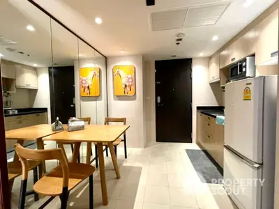 Modern kitchen with dining area, featuring sleek cabinetry and contemporary decor.