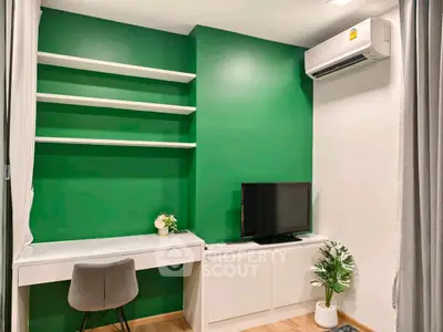 Modern study room with green accent wall, built-in desk, and air conditioning.