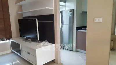 Modern living room with sleek TV unit and adjacent kitchen area