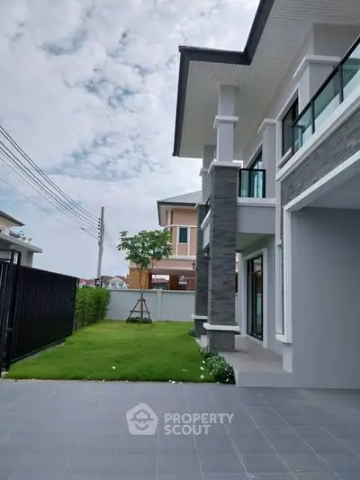 Modern two-story house with spacious driveway and lush green lawn in a serene neighborhood.