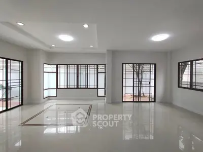 Spacious modern living room with large windows and elegant lighting