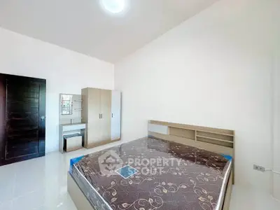 Spacious bedroom with modern furniture and ample natural light